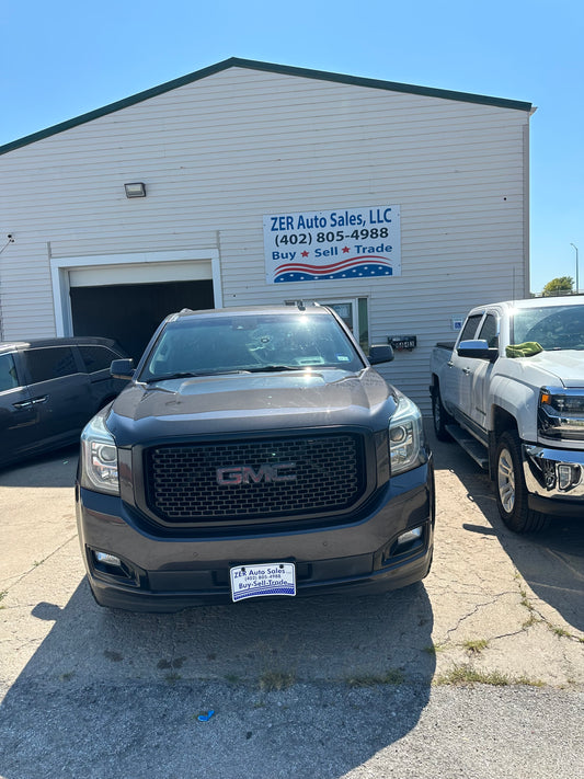 SUV parked in front of a building with a sign on the wall.